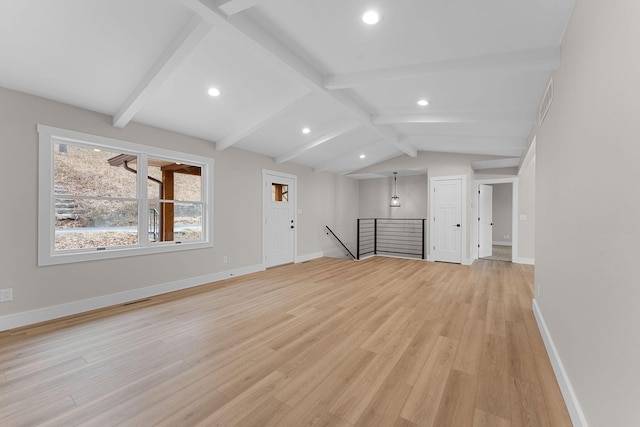 unfurnished living room with visible vents, light wood-style flooring, vaulted ceiling with beams, and baseboards