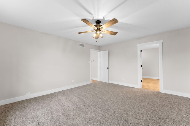 interior space featuring ceiling fan, light colored carpet, visible vents, and baseboards