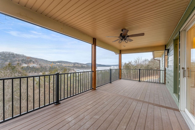 wooden deck featuring a mountain view and ceiling fan