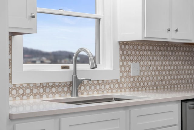 details with a sink, tasteful backsplash, white cabinetry, light countertops, and dishwasher