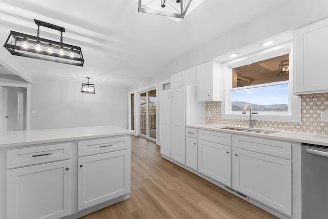 kitchen with plenty of natural light, light wood-style flooring, dishwasher, and a sink