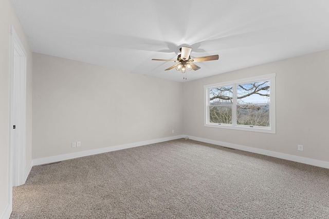 empty room with baseboards, carpet floors, visible vents, and a ceiling fan