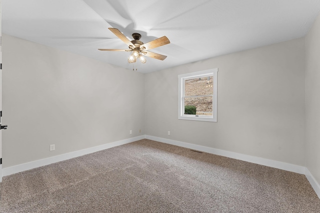 carpeted empty room featuring visible vents, a ceiling fan, and baseboards