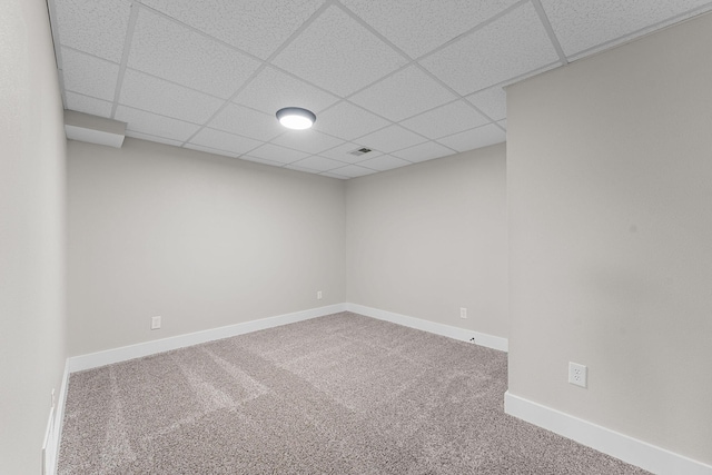 spare room featuring a drop ceiling, visible vents, baseboards, and carpet floors