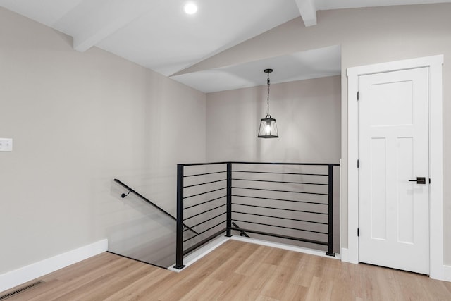 staircase with lofted ceiling with beams, wood finished floors, and visible vents