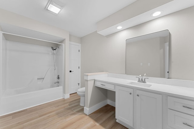 bathroom with visible vents, toilet, wood finished floors, washtub / shower combination, and vanity