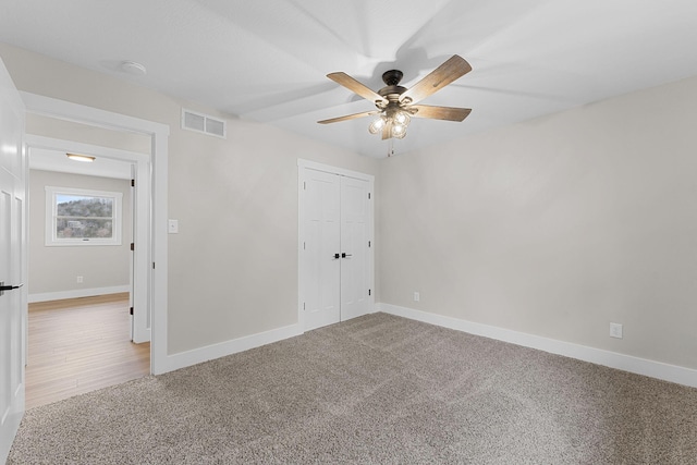 unfurnished bedroom with a closet, visible vents, baseboards, and carpet