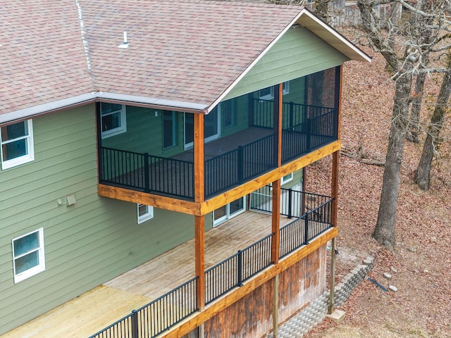 view of home's exterior featuring roof with shingles and a sunroom