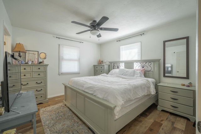 bedroom featuring dark wood finished floors, a ceiling fan, and baseboards