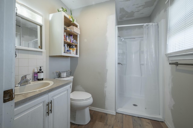 full bathroom with toilet, curtained shower, wood finished floors, decorative backsplash, and vanity