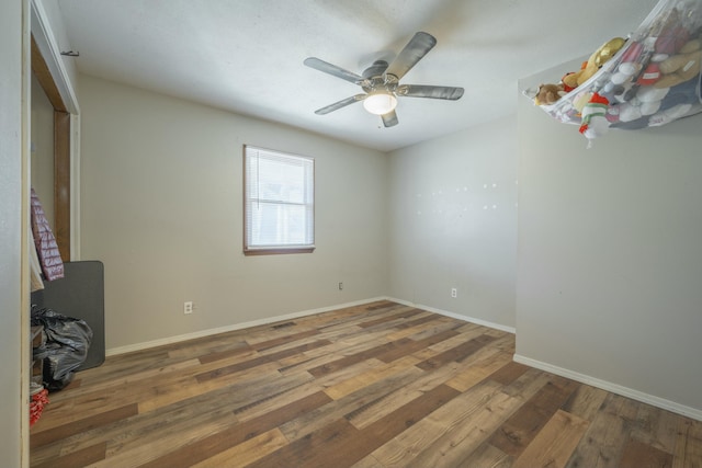 unfurnished bedroom featuring a ceiling fan, baseboards, and wood finished floors