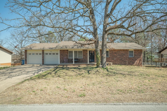 ranch-style house with a garage, driveway, brick siding, and a front yard