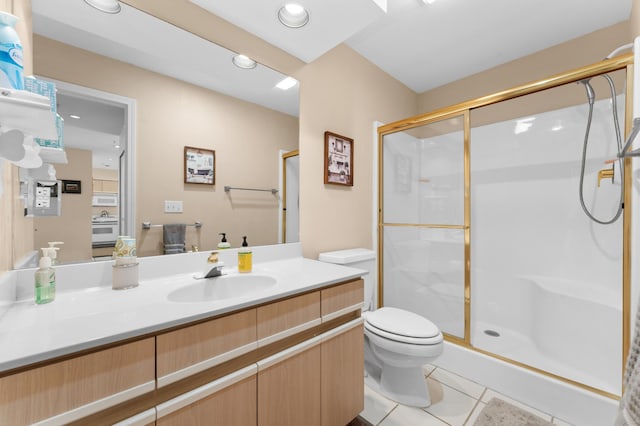 bathroom featuring vanity, tile patterned floors, toilet, and a stall shower