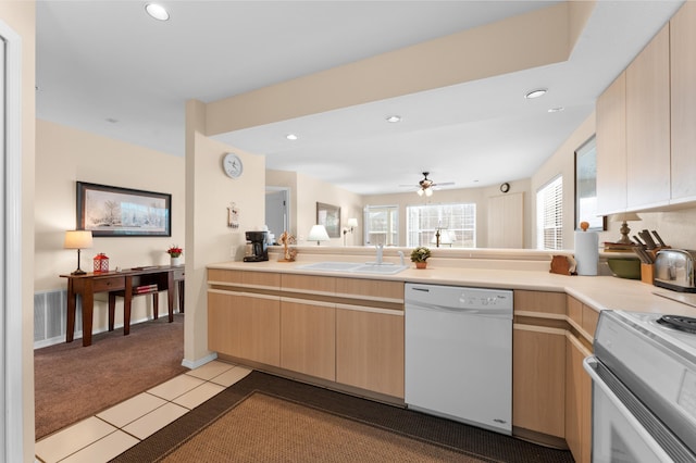 kitchen featuring range with electric cooktop, light brown cabinetry, dishwasher, light carpet, and a sink