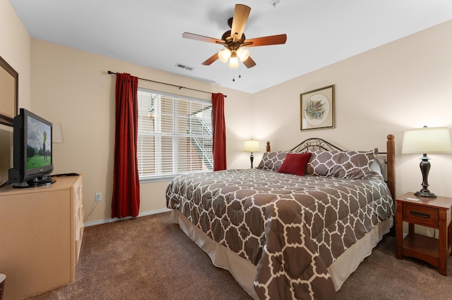 carpeted bedroom with visible vents, baseboards, and a ceiling fan