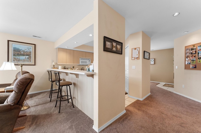 hallway featuring light tile patterned floors, visible vents, baseboards, recessed lighting, and light carpet