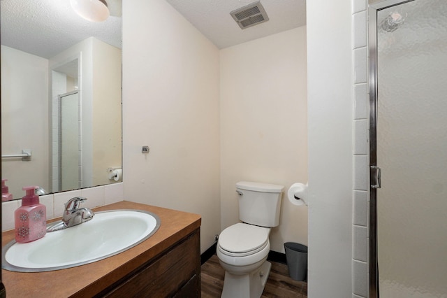 full bathroom featuring visible vents, toilet, a stall shower, wood finished floors, and vanity