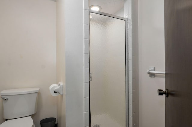 bathroom with a shower stall and toilet