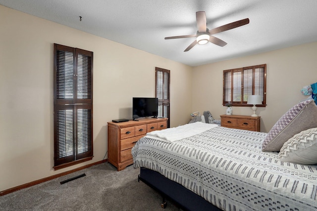 carpeted bedroom featuring visible vents, baseboards, multiple windows, and a textured ceiling