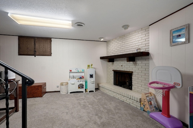 playroom featuring visible vents, carpet flooring, and a brick fireplace