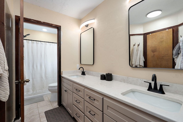 bathroom featuring tile patterned floors, toilet, double vanity, and a sink