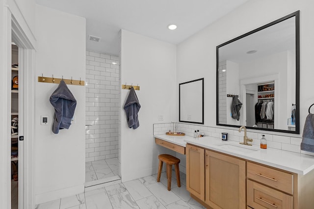 full bathroom with tasteful backsplash, a walk in shower, baseboards, marble finish floor, and vanity