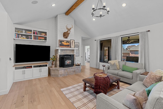 living area featuring baseboards, a chandelier, beamed ceiling, a wood stove, and light wood-style floors