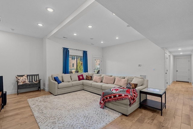 living area with visible vents, recessed lighting, light wood-type flooring, and baseboards