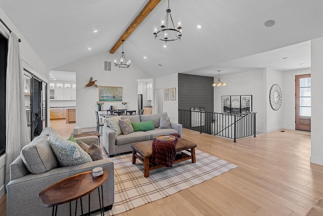 living area featuring beamed ceiling, visible vents, light wood-style floors, and an inviting chandelier