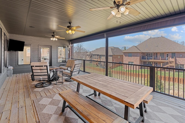 sunroom featuring a residential view, wooden ceiling, and a ceiling fan