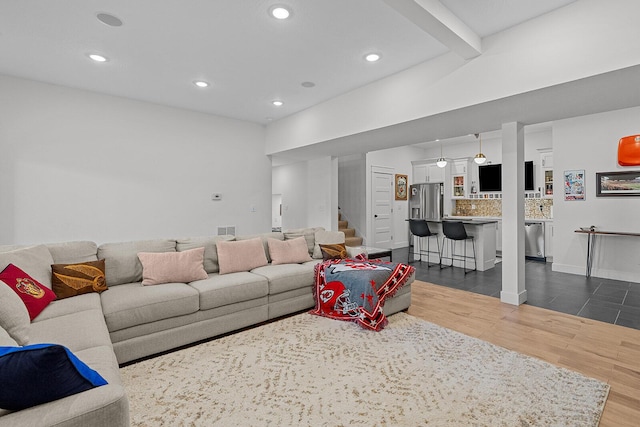 living room with recessed lighting, visible vents, dark wood-type flooring, and stairs