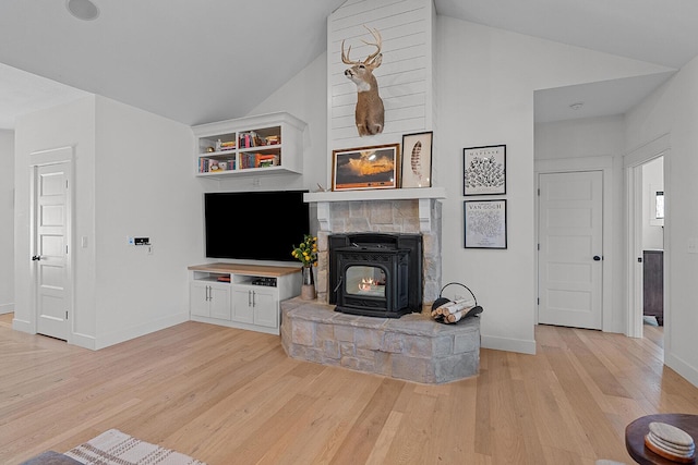 living area featuring baseboards, light wood-style floors, and high vaulted ceiling