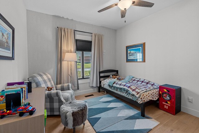 bedroom with visible vents, baseboards, wood finished floors, and a ceiling fan