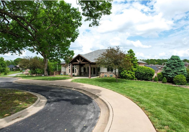 craftsman-style house with a front lawn and stone siding