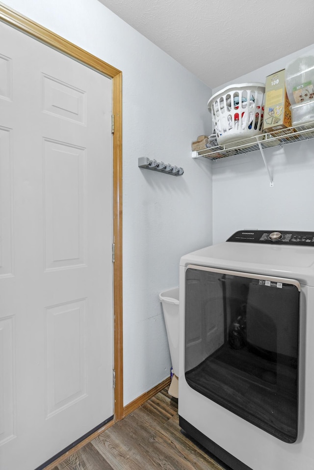 laundry room featuring laundry area, washer / dryer, baseboards, and wood finished floors