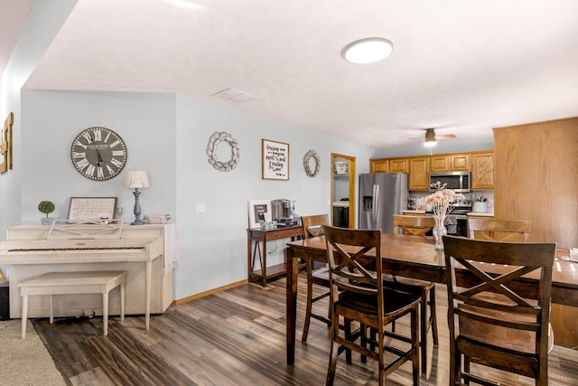 dining space with visible vents, baseboards, dark wood-type flooring, and a ceiling fan