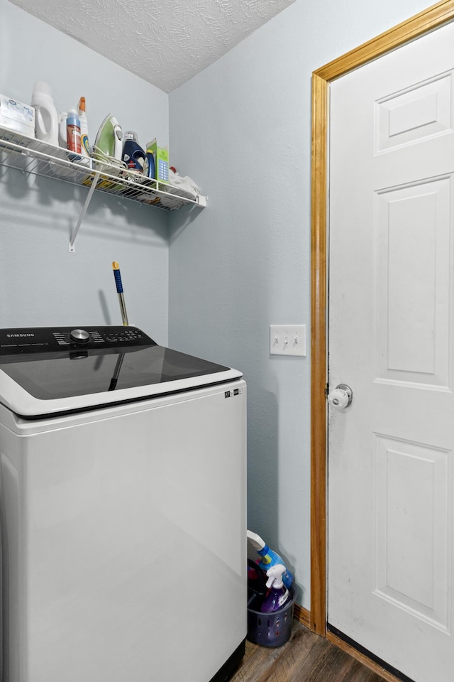 laundry area featuring washer / clothes dryer, a textured ceiling, dark wood-style floors, and laundry area