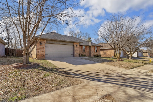 ranch-style house with fence, driveway, an attached garage, a shingled roof, and brick siding