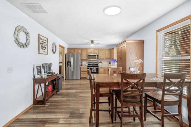 dining space featuring light wood-type flooring, visible vents, baseboards, and ceiling fan