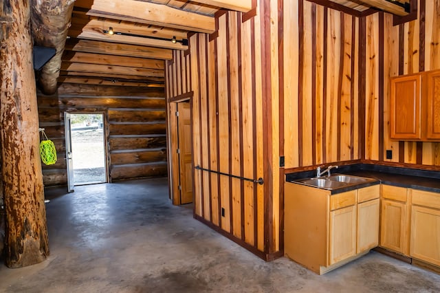 interior space with dark countertops, rustic walls, concrete floors, and a sink