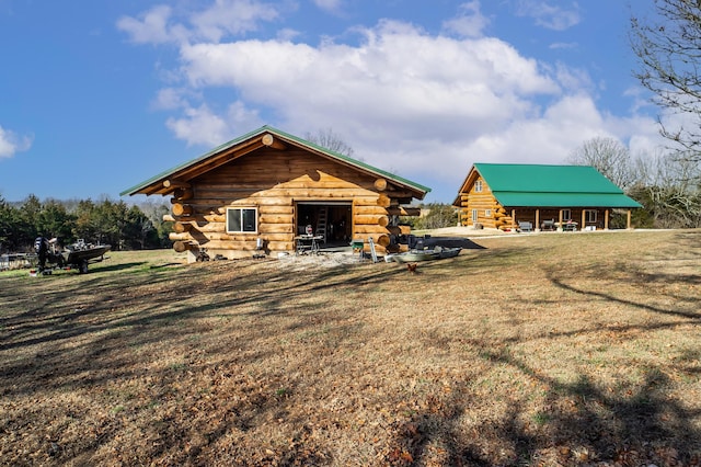 view of side of home featuring log exterior and a lawn