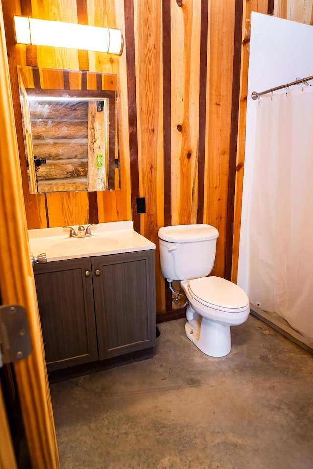 bathroom with a shower with shower curtain, concrete floors, toilet, and vanity