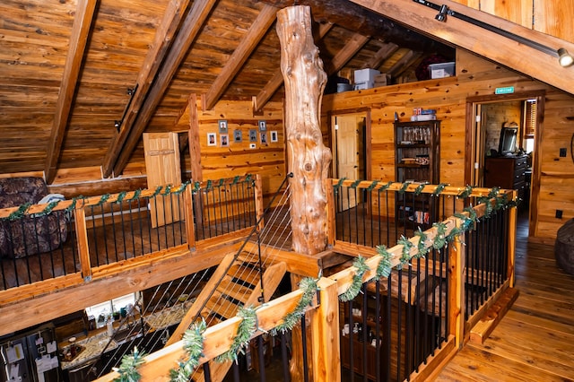 interior space with wooden walls, wooden ceiling, vaulted ceiling with beams, and wood-type flooring