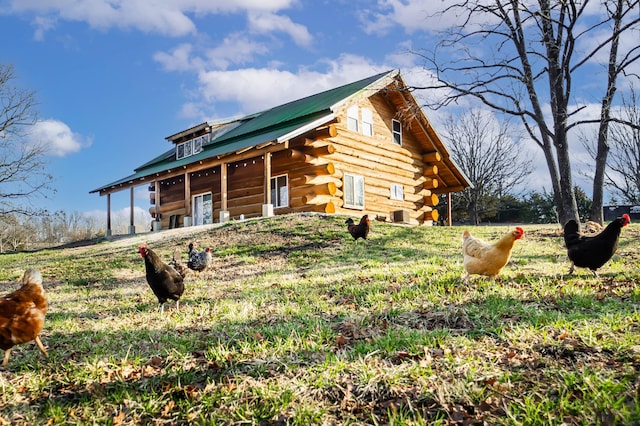 view of front of home with log exterior and metal roof