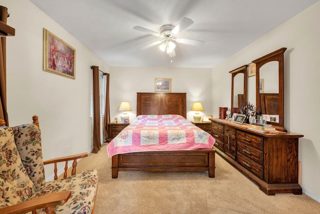 bedroom featuring baseboards, light colored carpet, and ceiling fan