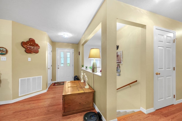 foyer featuring visible vents, light wood-type flooring, and baseboards