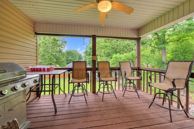 wooden deck featuring grilling area and ceiling fan