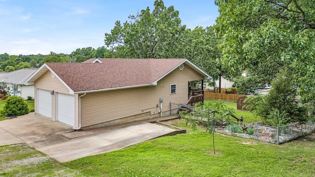 exterior space featuring a garage, a lawn, a shingled roof, and fence