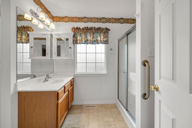 bathroom with visible vents, a stall shower, vanity, and baseboards