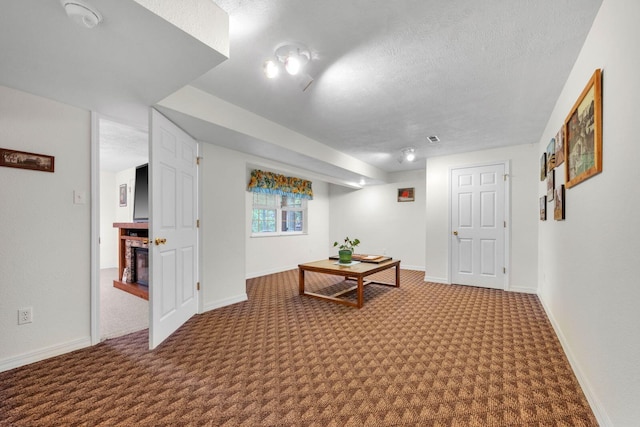 hall with baseboards, a textured ceiling, and carpet floors